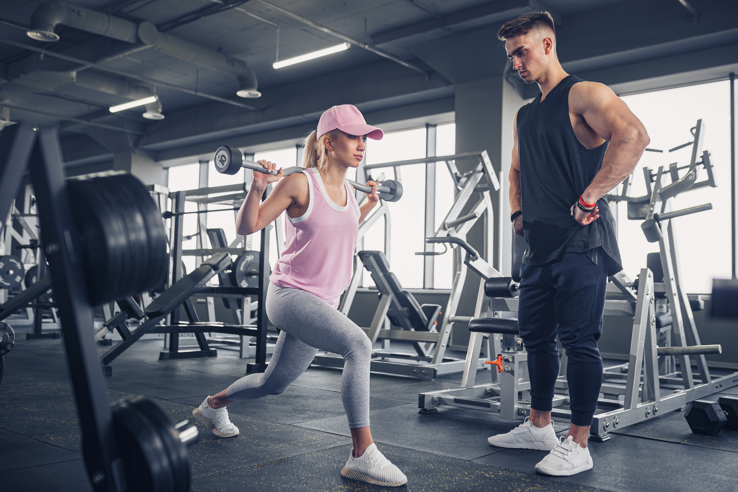 Fitness Coach Training Young Woman at the Gym 